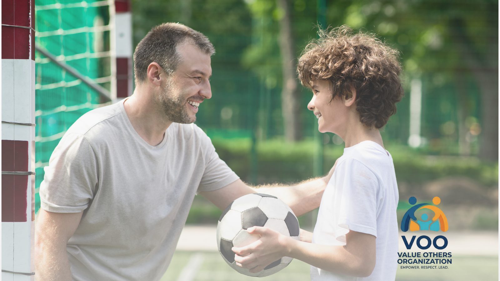 A mentor and youth sharing a moment on the field